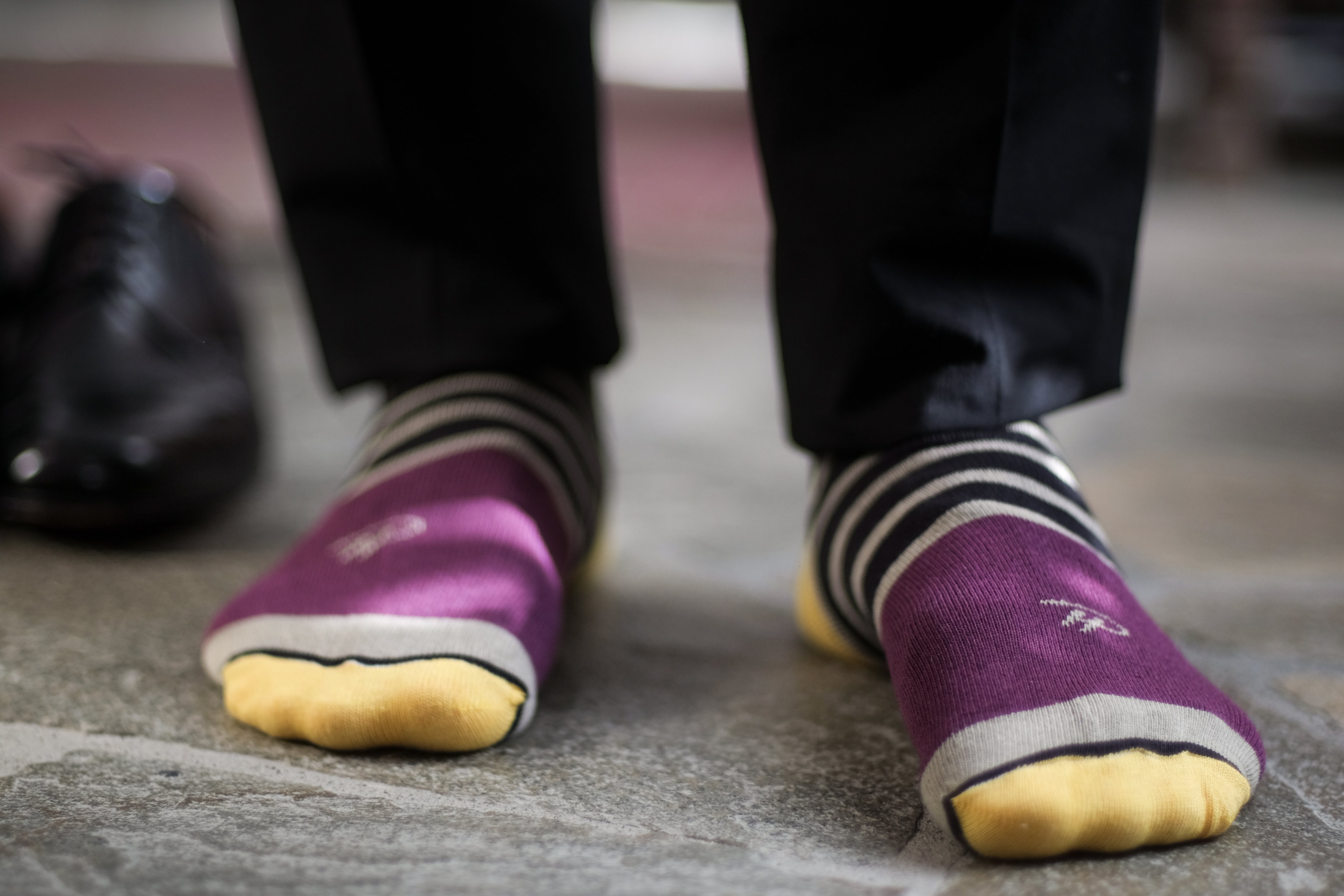 beige and black striped over the calf dress socks with plum foot and yellow toe, black dress pants