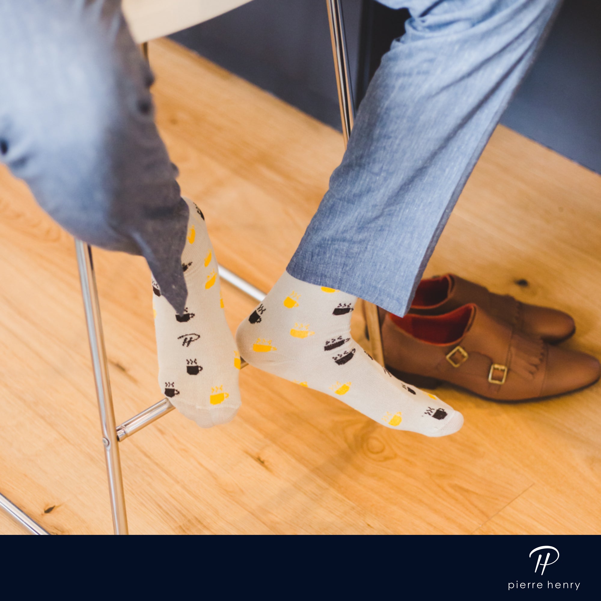 light grey over the calf dress socks with black and yellow hot coffee mug print, grey dress pants, light brown shoes on floor