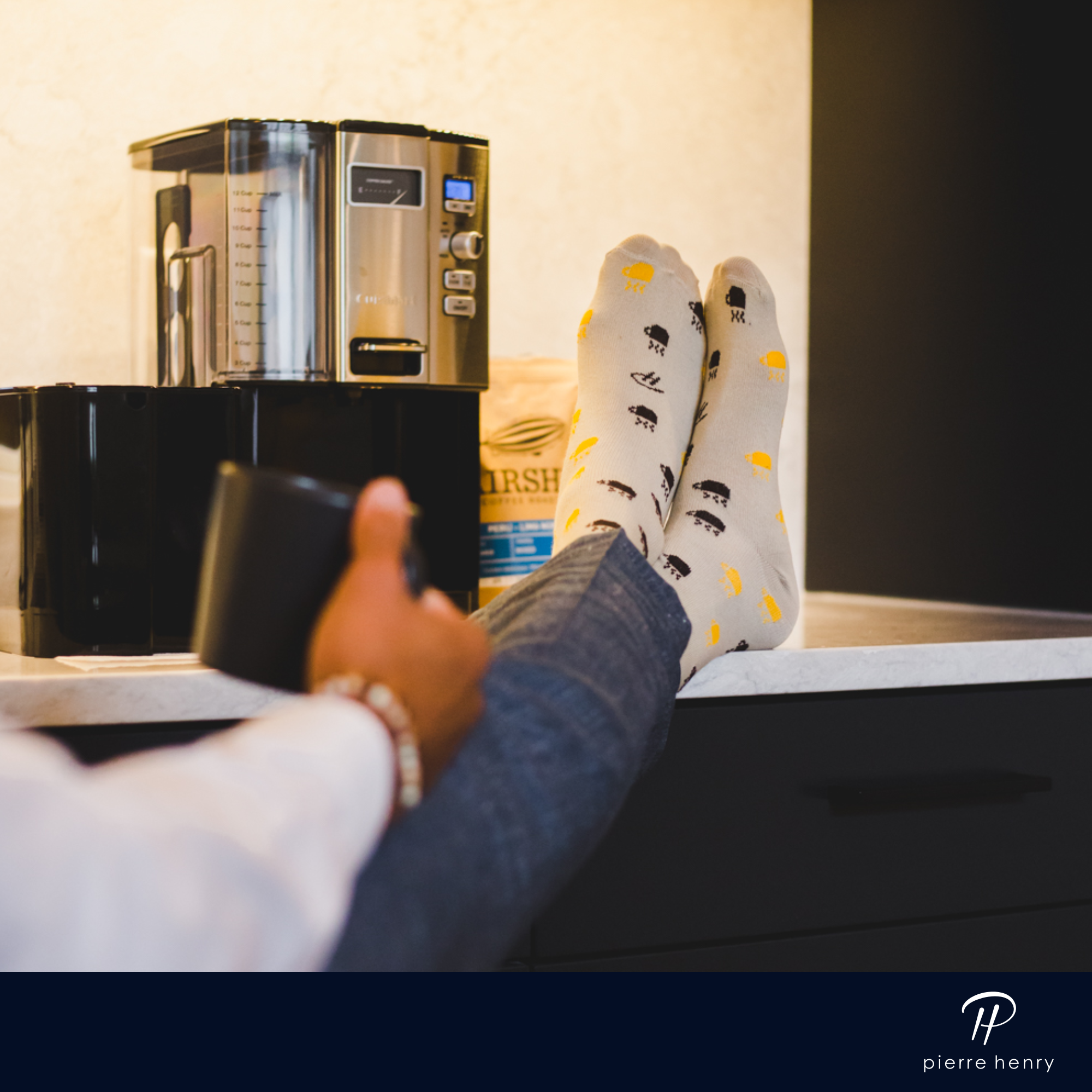light grey over the calf dress socks with black and yellow hot mug prints, grey dress pants, a black coffee cup, a coffee machine