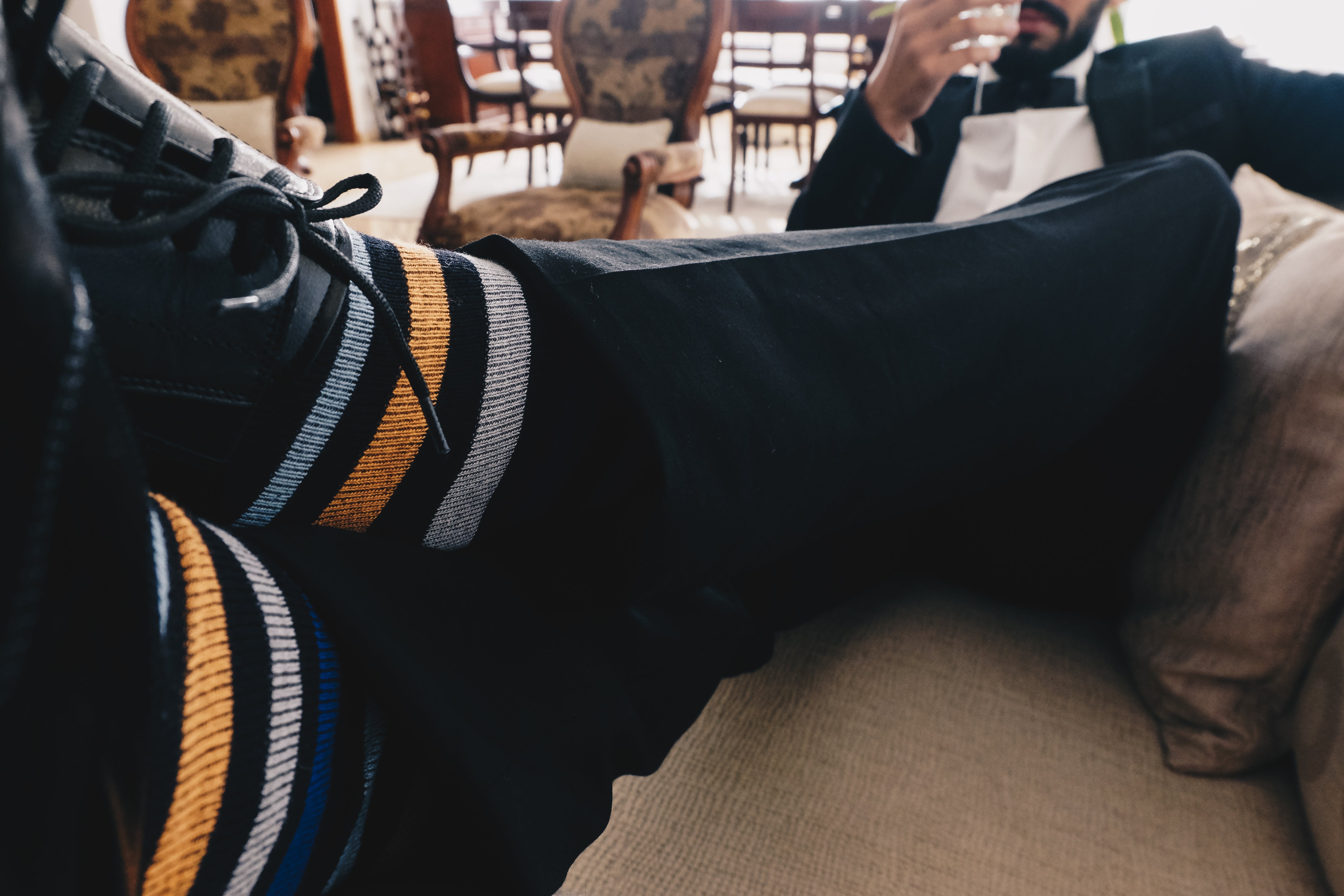 black over the calf dress socks with orange white and blue stripes, black dress shoes, black dress pants