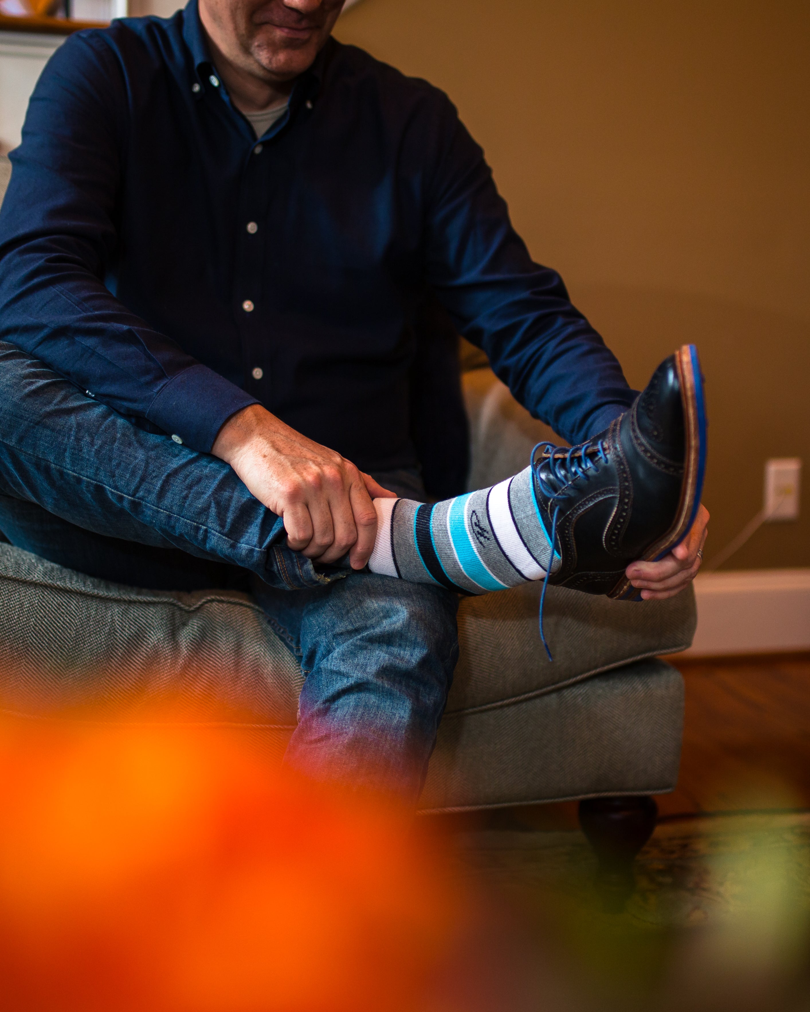 light grey over the calf dress socks with white black and light blue stripes, black dress shoes with blue laces, blue jeans, blue shirt