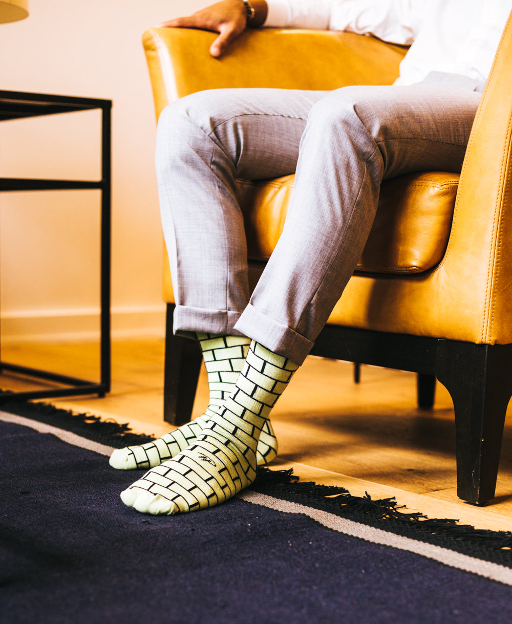 green over the calf dress socks with black brick pattern, leather chair, grey dress pants