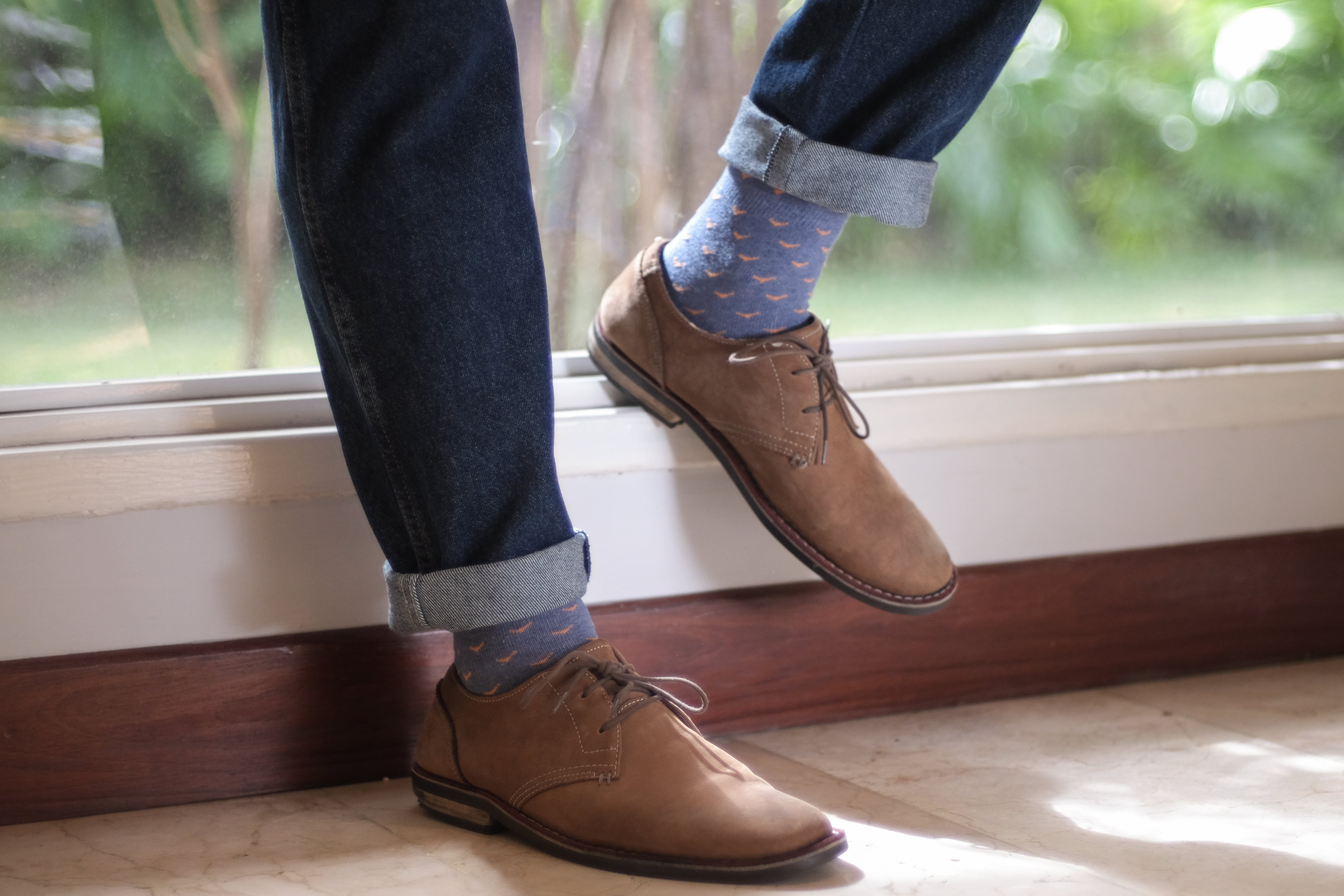 light blue over the calf dress socks with orange birds, light brown dress shoes, blue jeans