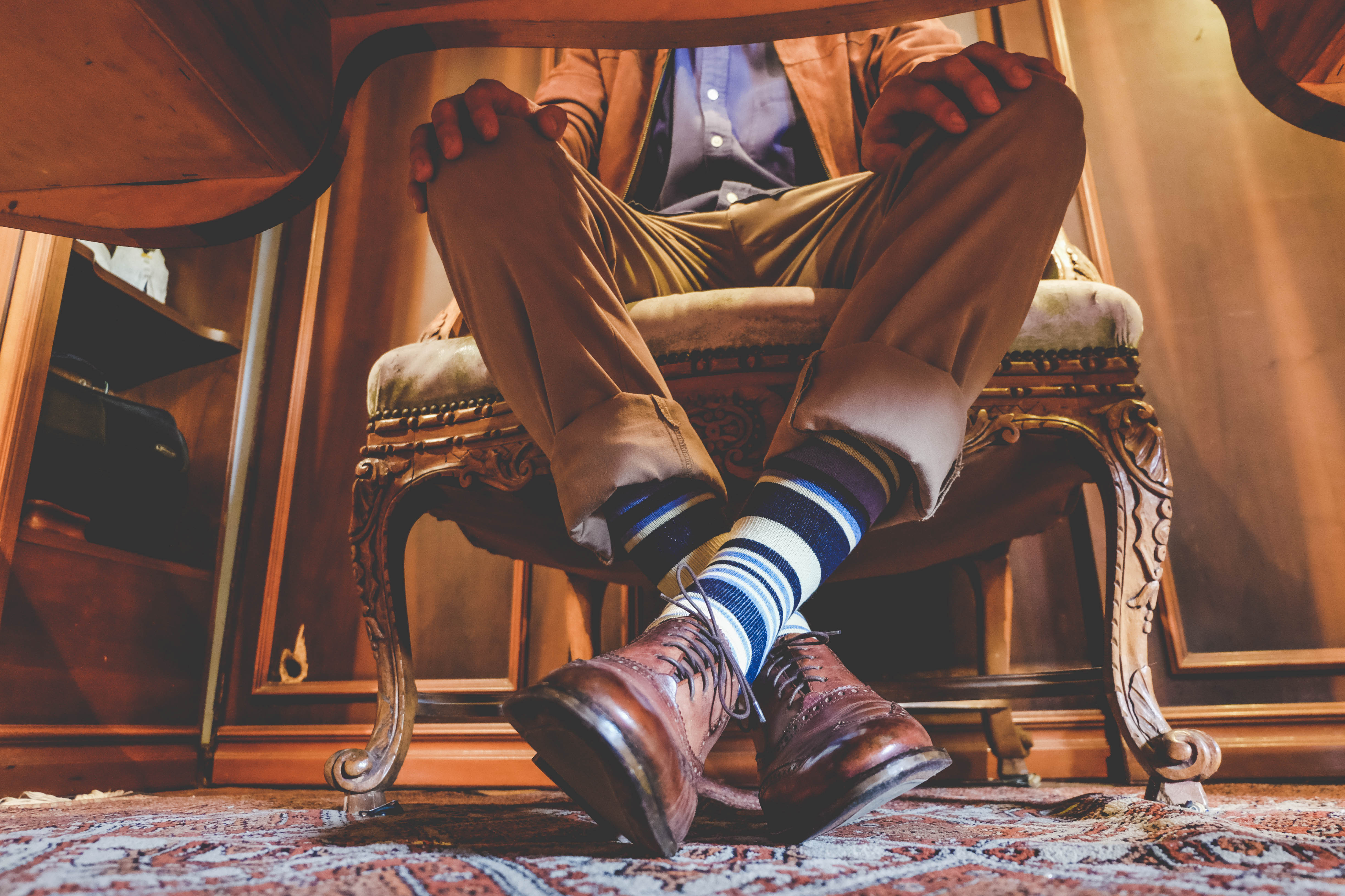 beige blue navy and back over the calf dress socks, brown dress shoes, beige pants, blue button down dress shirt
