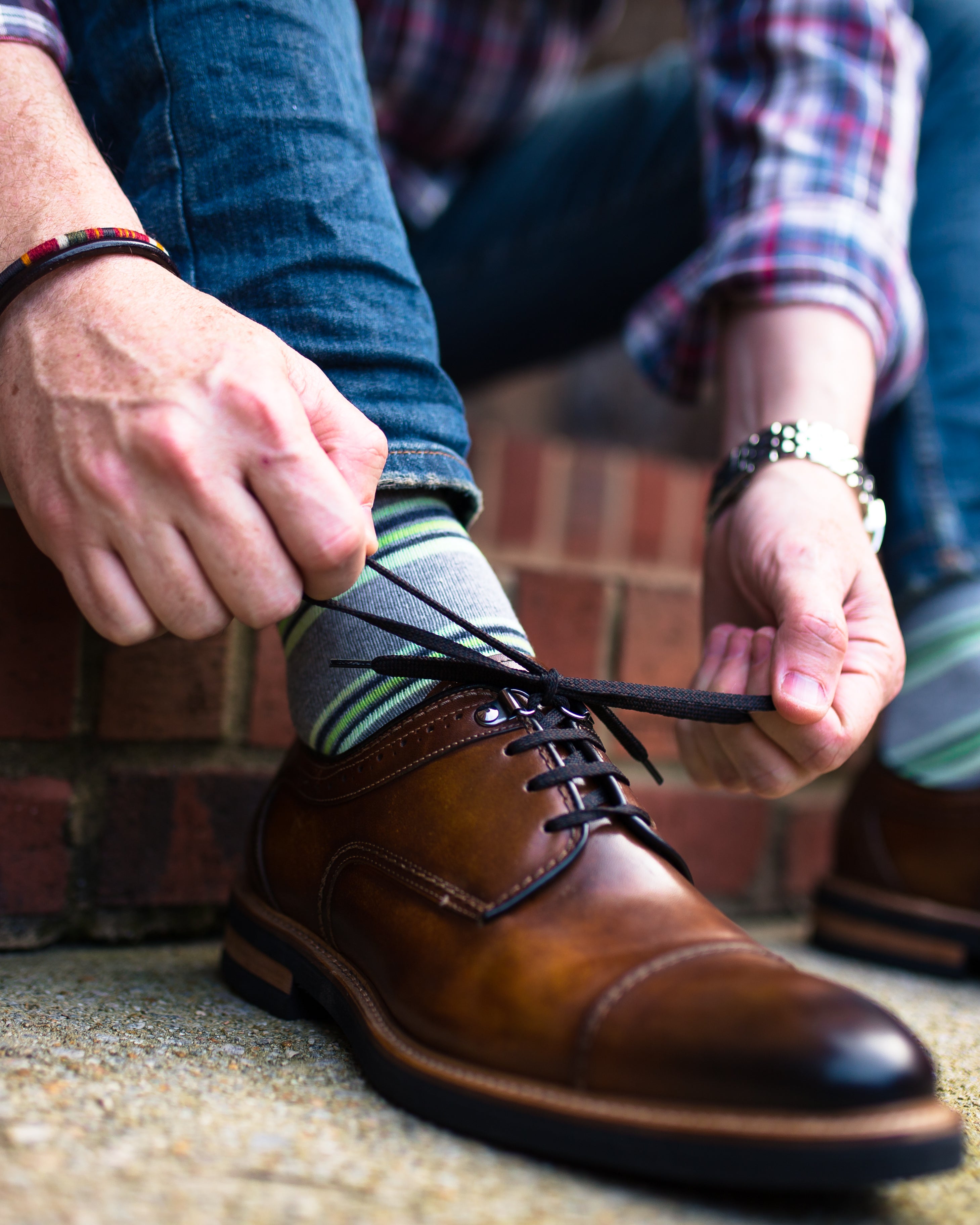 light grey over the calf dress socks with lime green stripes, brown tying dress shoes, blue jeans