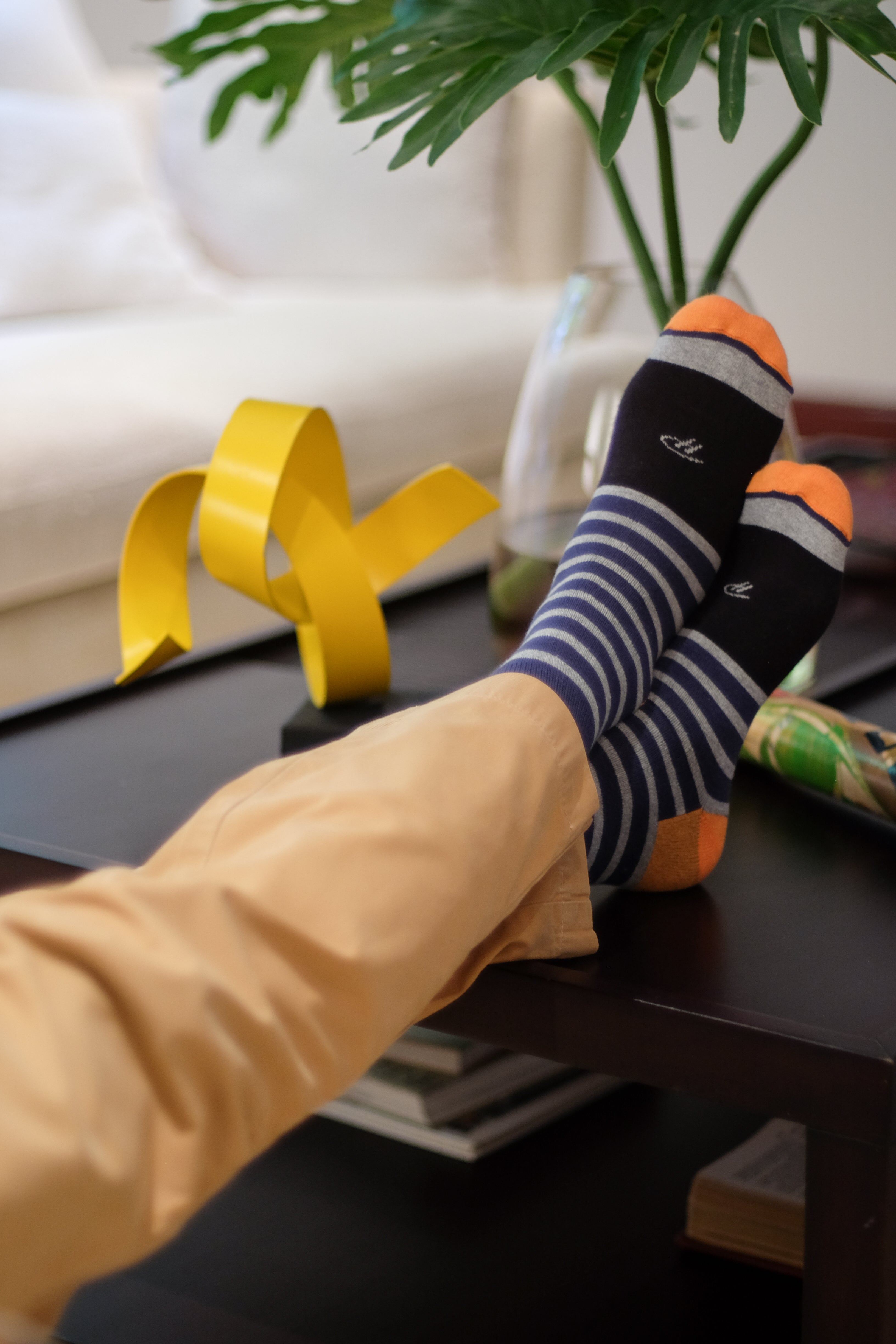 light grey over the calf dress socks with navy stripes black middle of foot and orange toe and heel, khaki pants