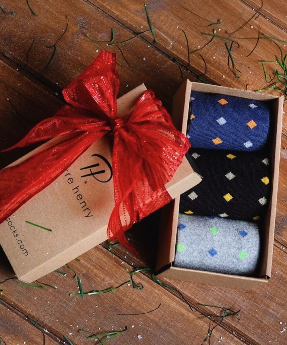 Pierre Henry box with red ribbon containing blue black and grey socks with colored diamond pattern