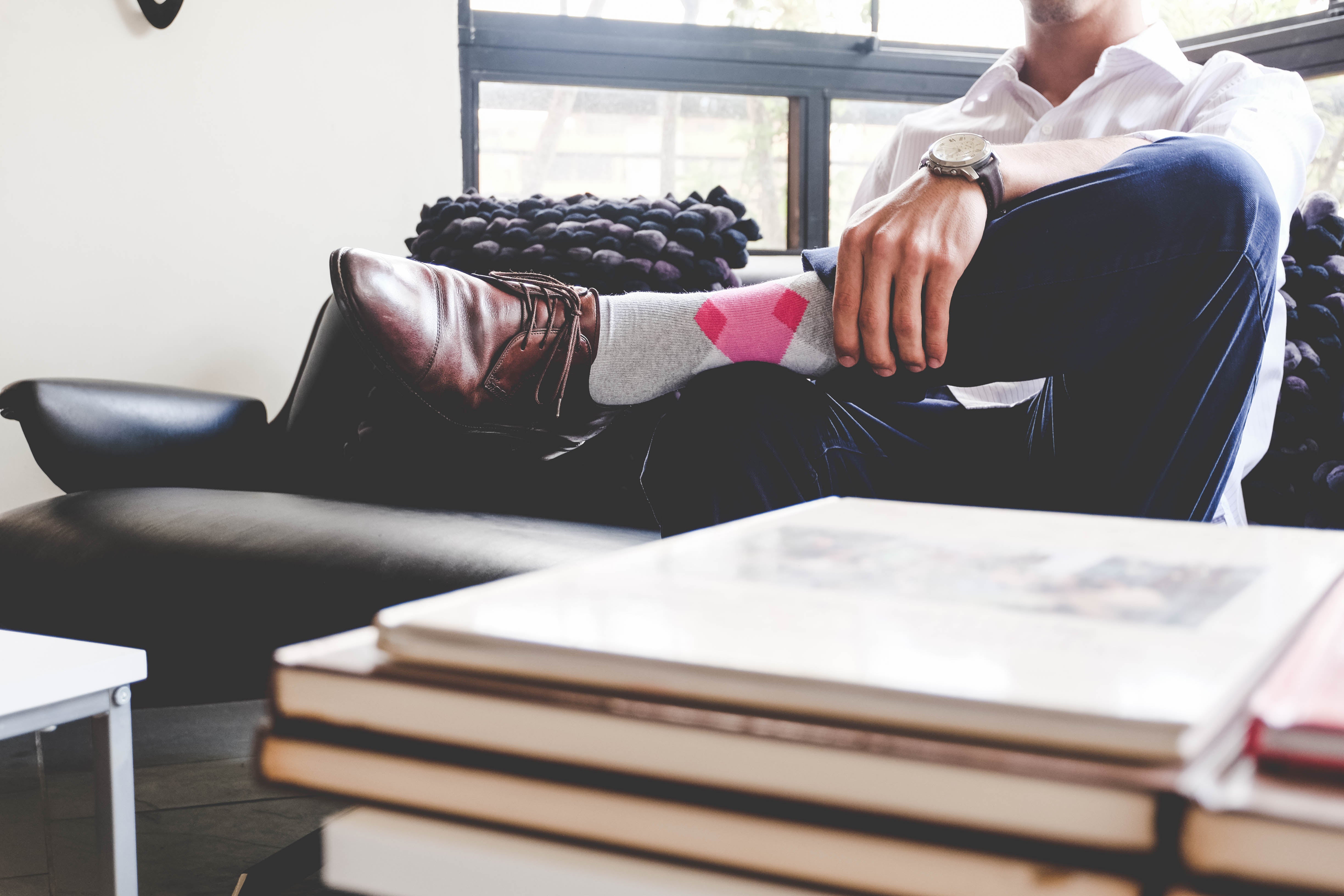 light grey over the calf dress socks with pink diamond in middle, brown dress shoes, blue jeans, watch, white button down dress shirt