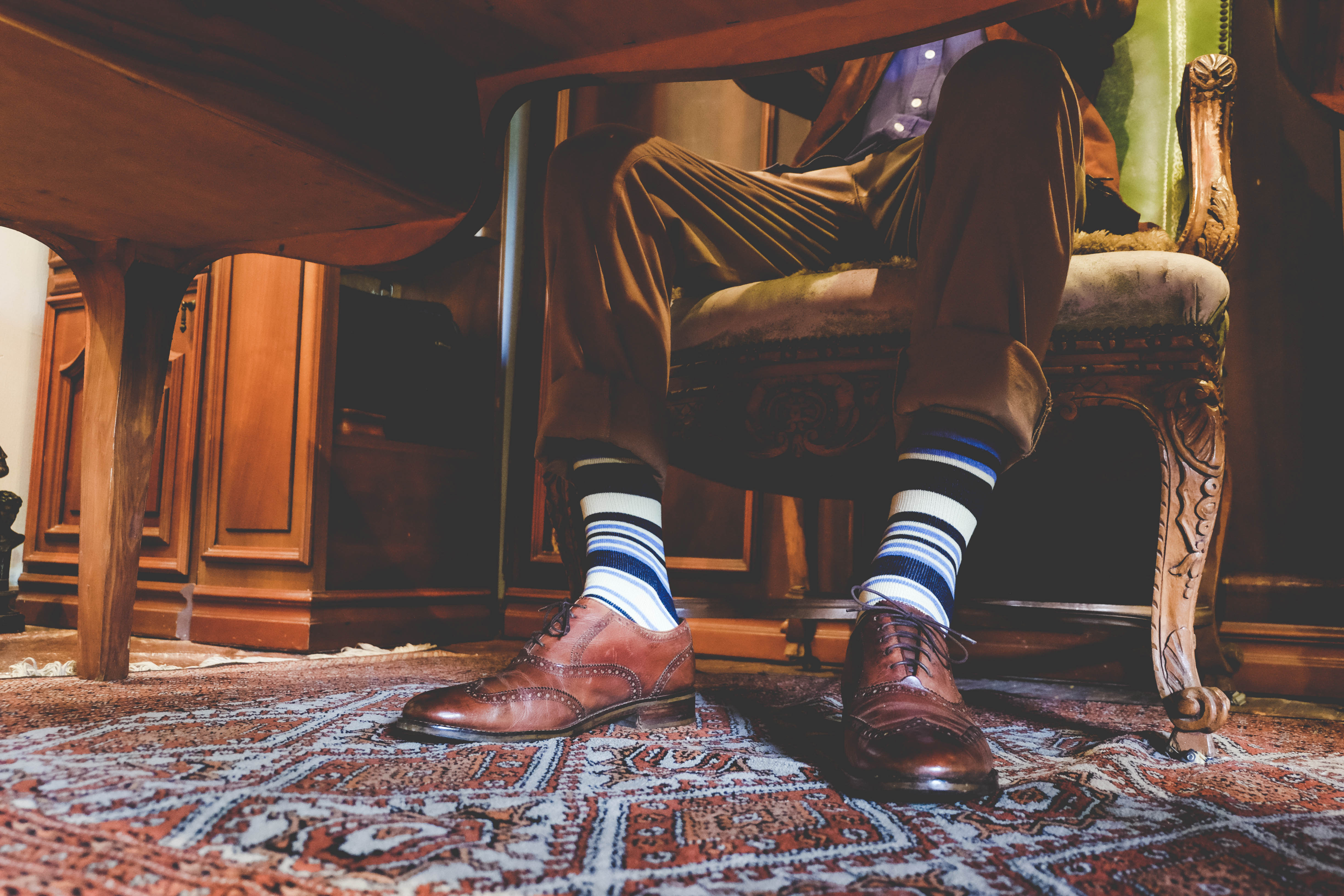 black navy beige and blue over the calf dress socks, brown dress shoes, brown pants, blue button down dress shirt, brown suit jacket