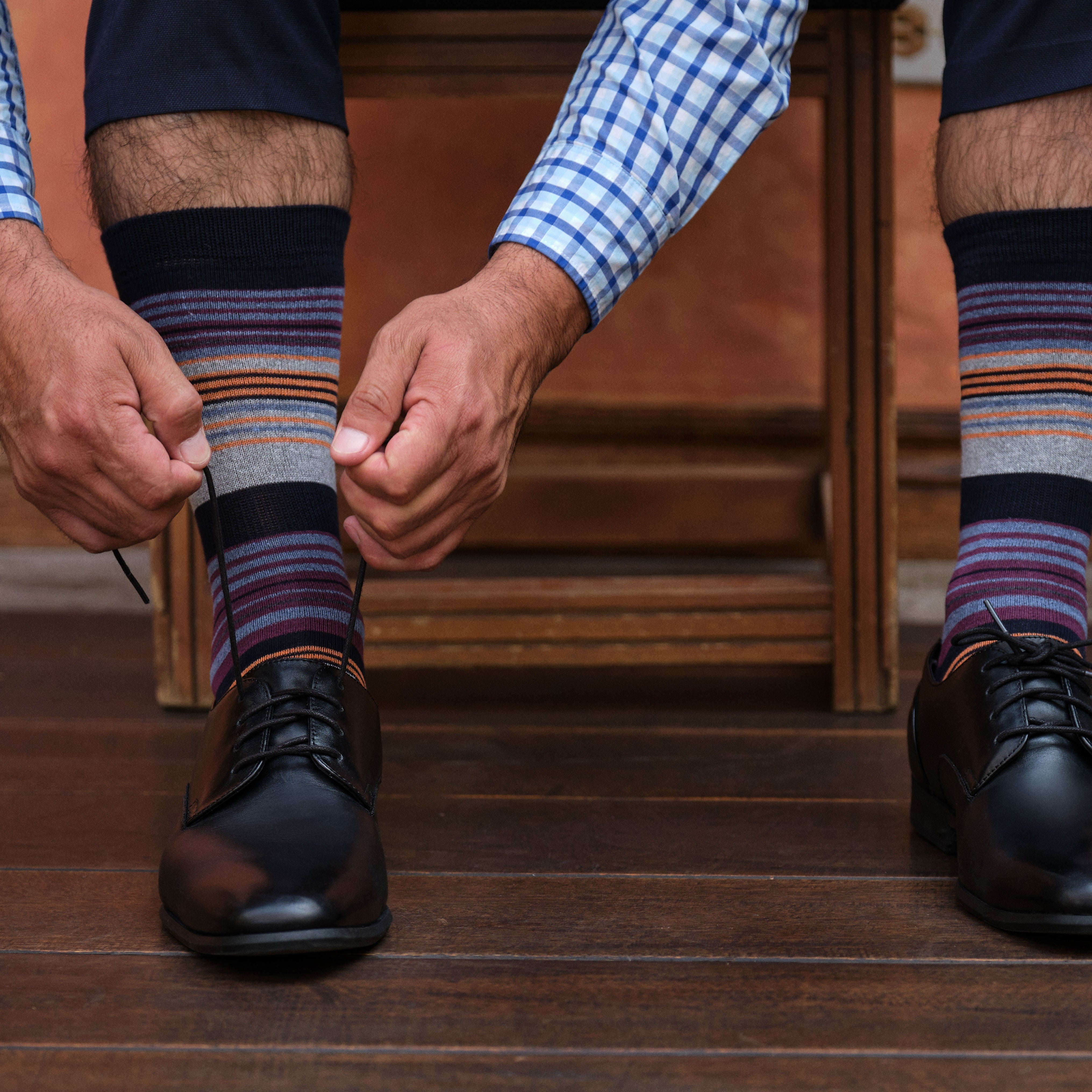 light grey mid calf dress socks with burgundy blue and orange stripes, black dress shoes
