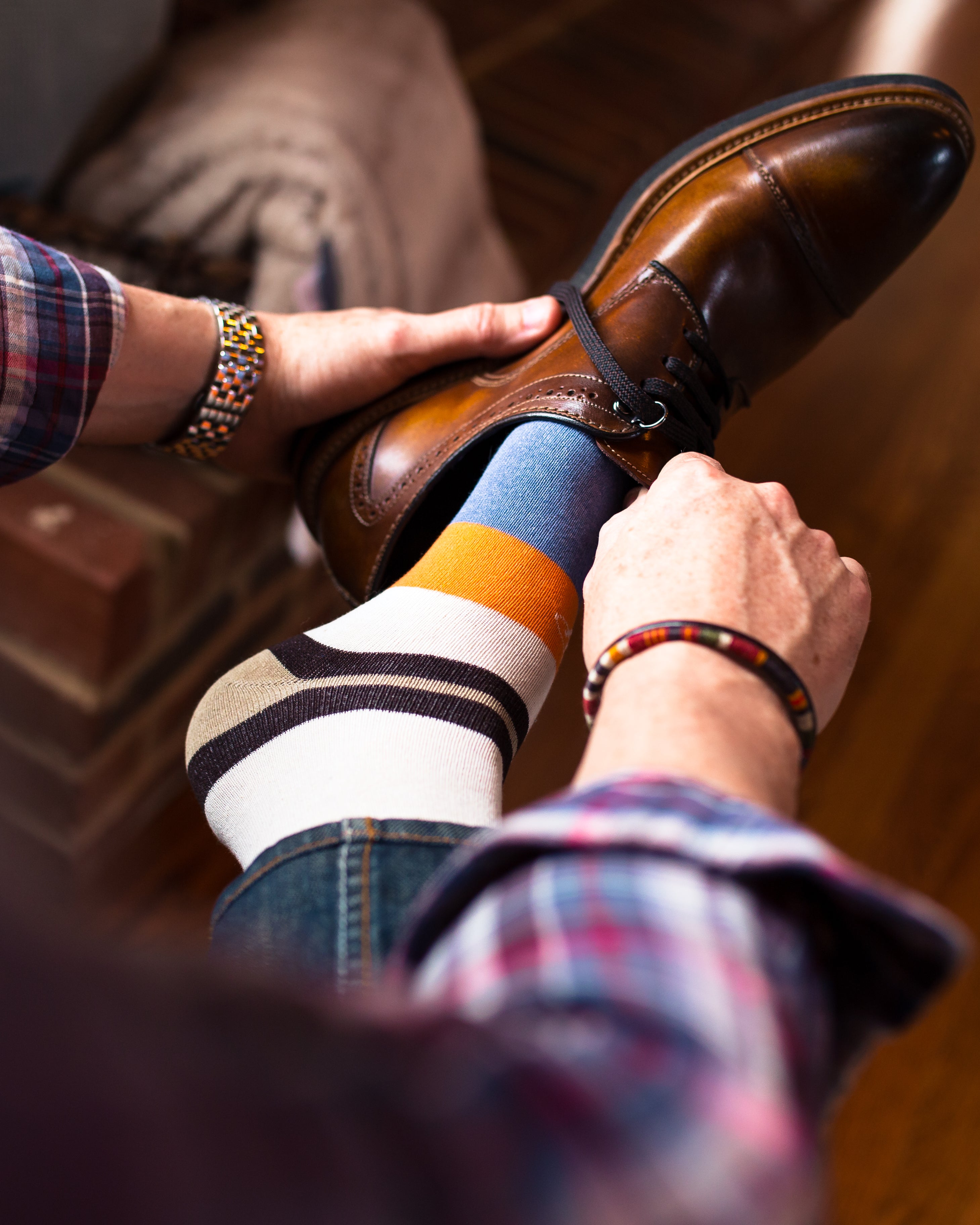 beige brown light blue and orange over the calf dress socks, brown dress shoes, blue jeans