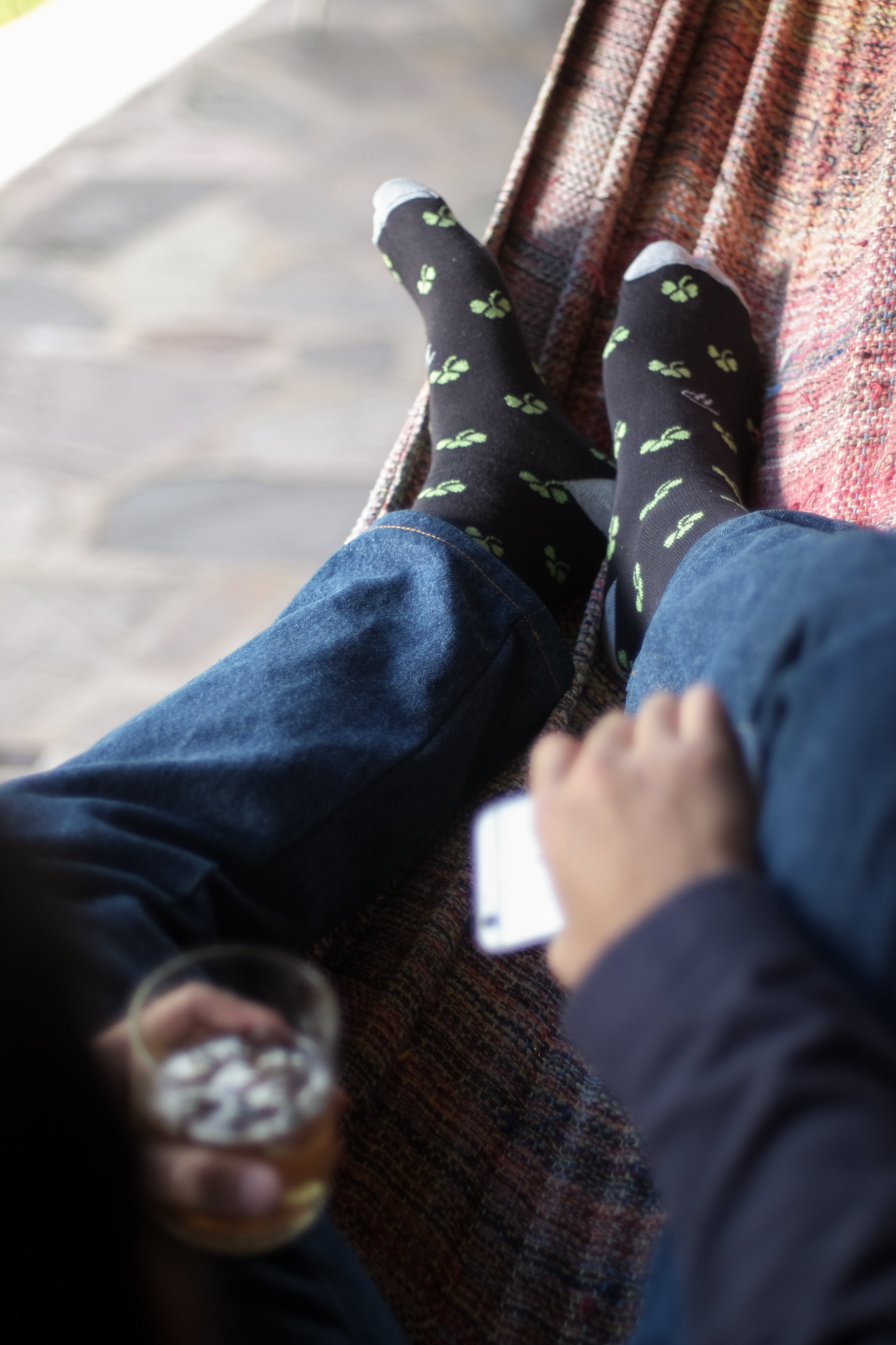 black over the calf dress socks with green clover pattern light grey toe and heel, blue jeans