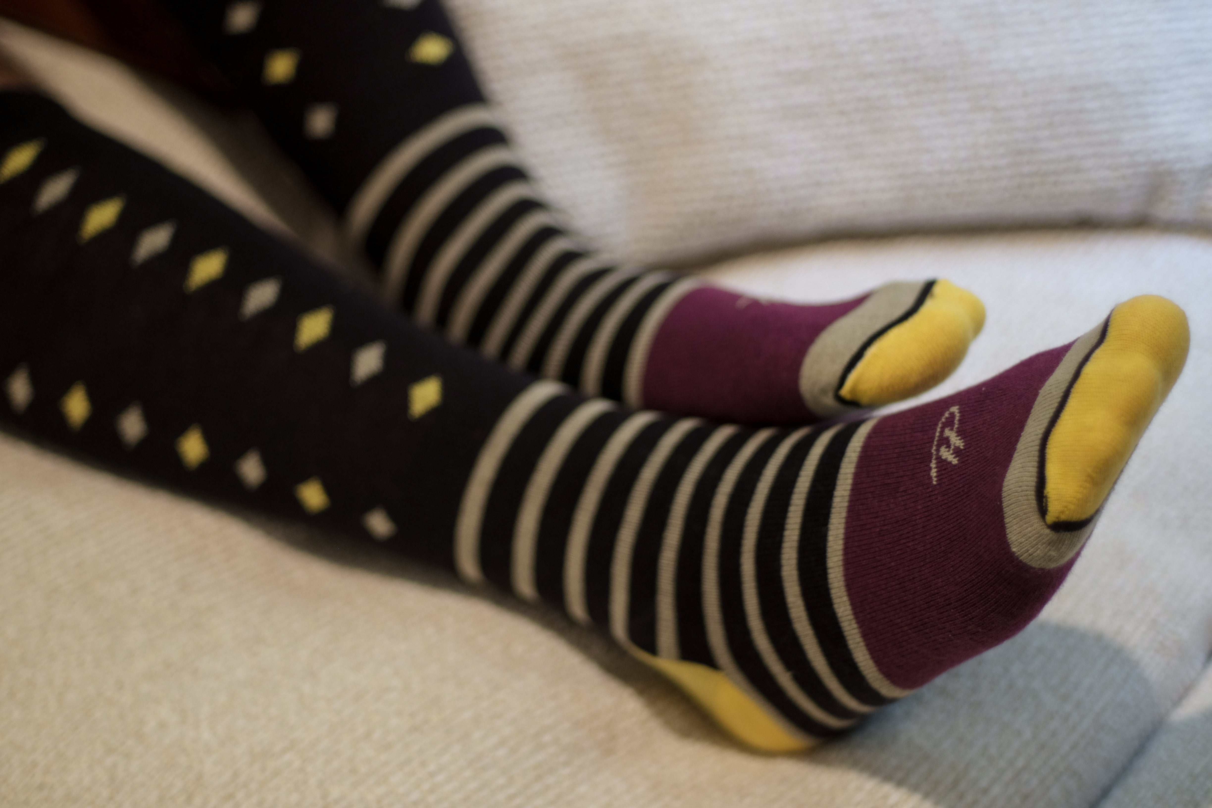 black over the calf dress socks with yellow and beige diamonds beige stripes and yellow toe and heel and plum middle of foot