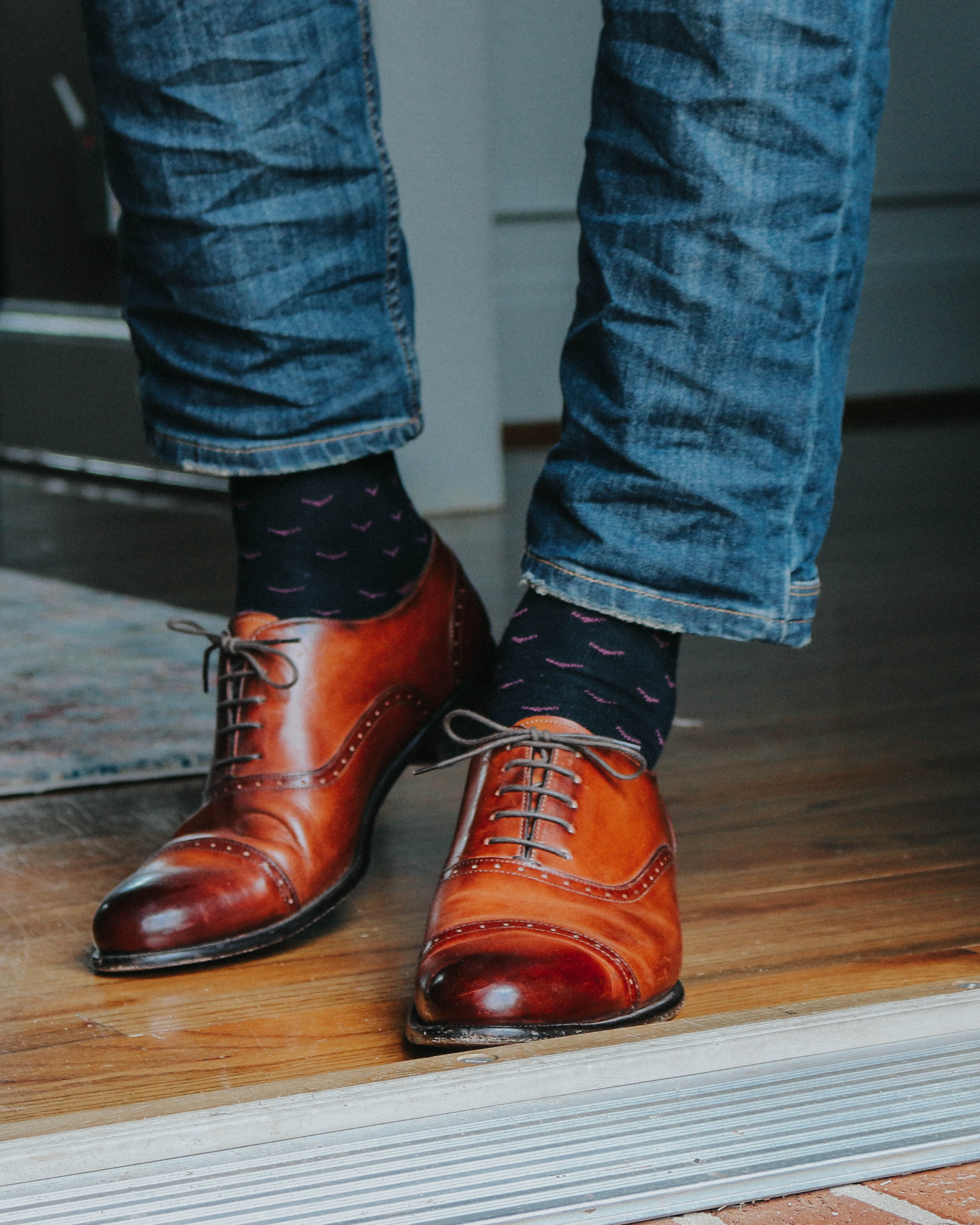 black over the calf dress socks with burgundy print, brown dress shoes, blue jeans