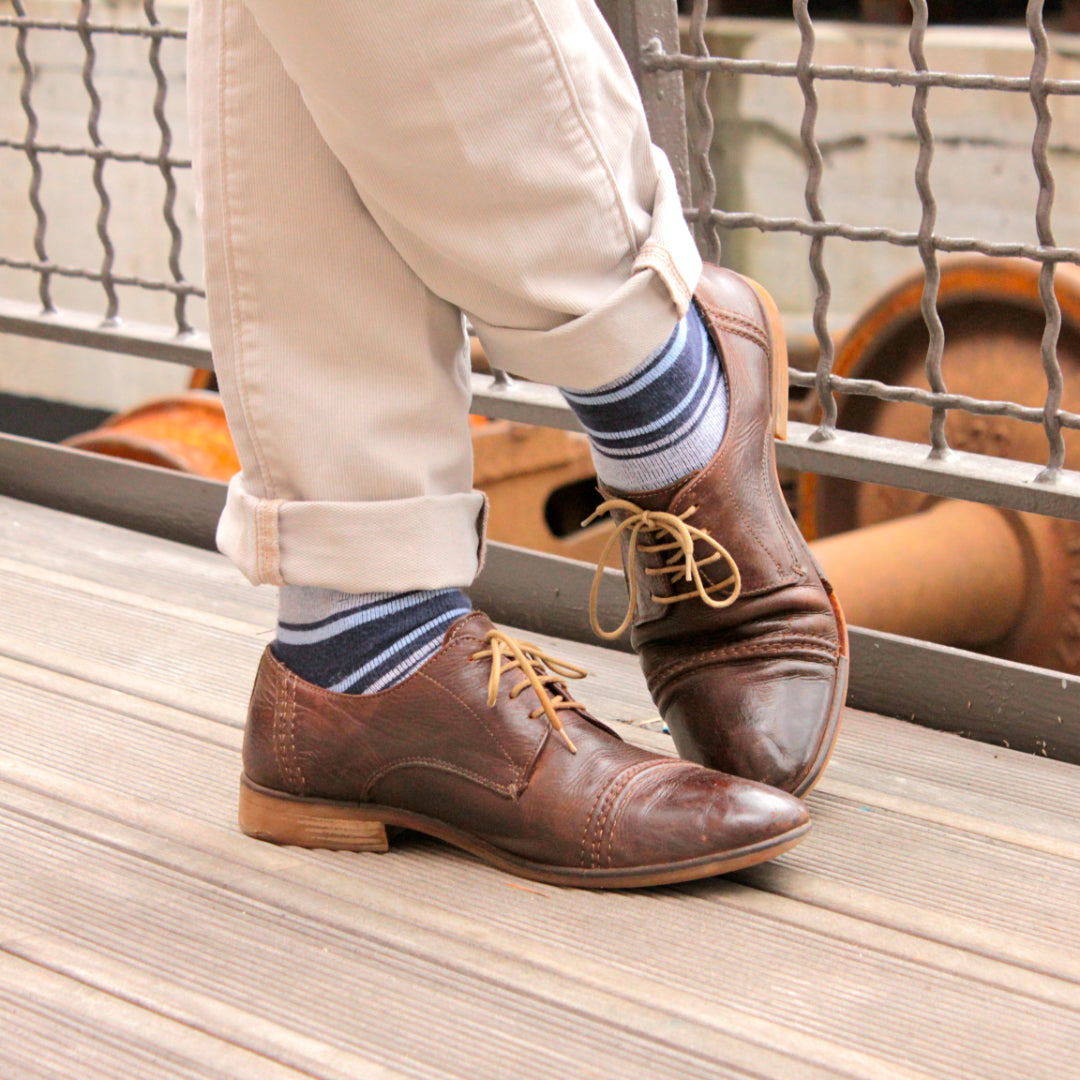 blue and grey striped over the calf dress socks, brown dress shoes, and beige pants