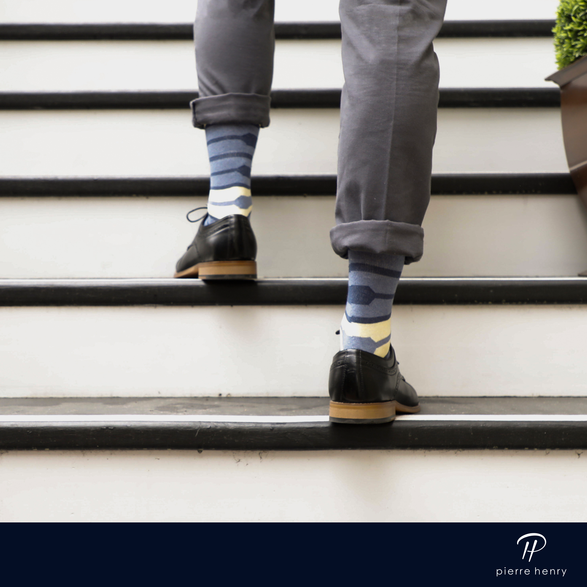 blue and yellow over the calf dress socks with lines,  black washed pants, on a staircase