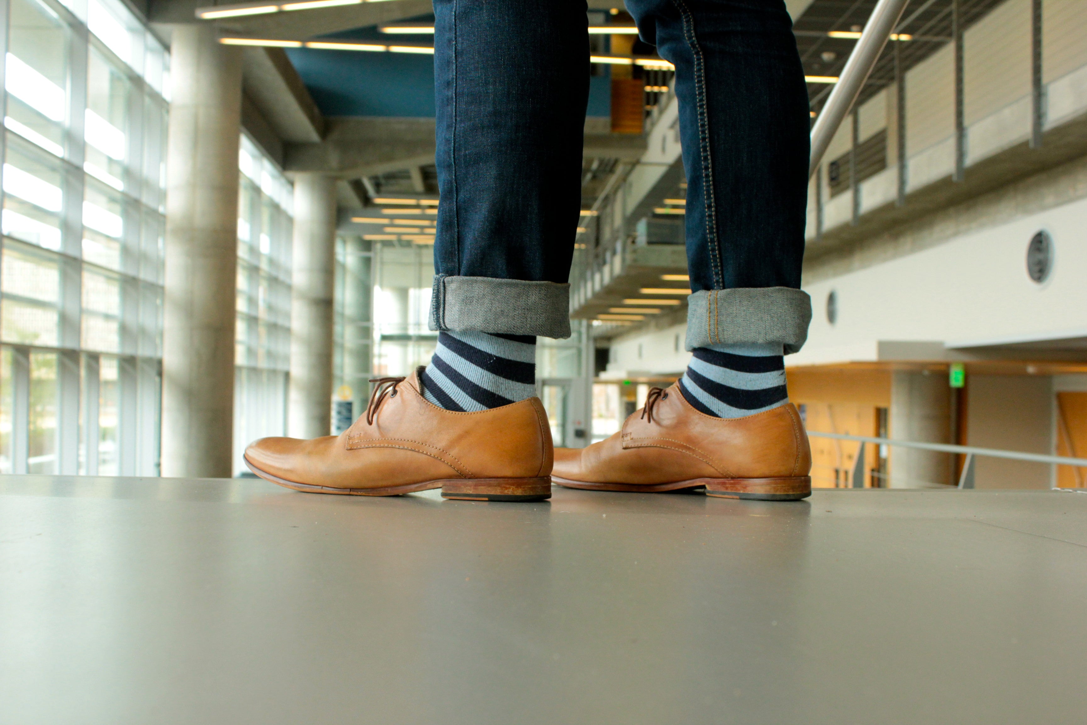 navy blue and light blue striped over the calf dress socks, light brown dress shoes, blue jeans