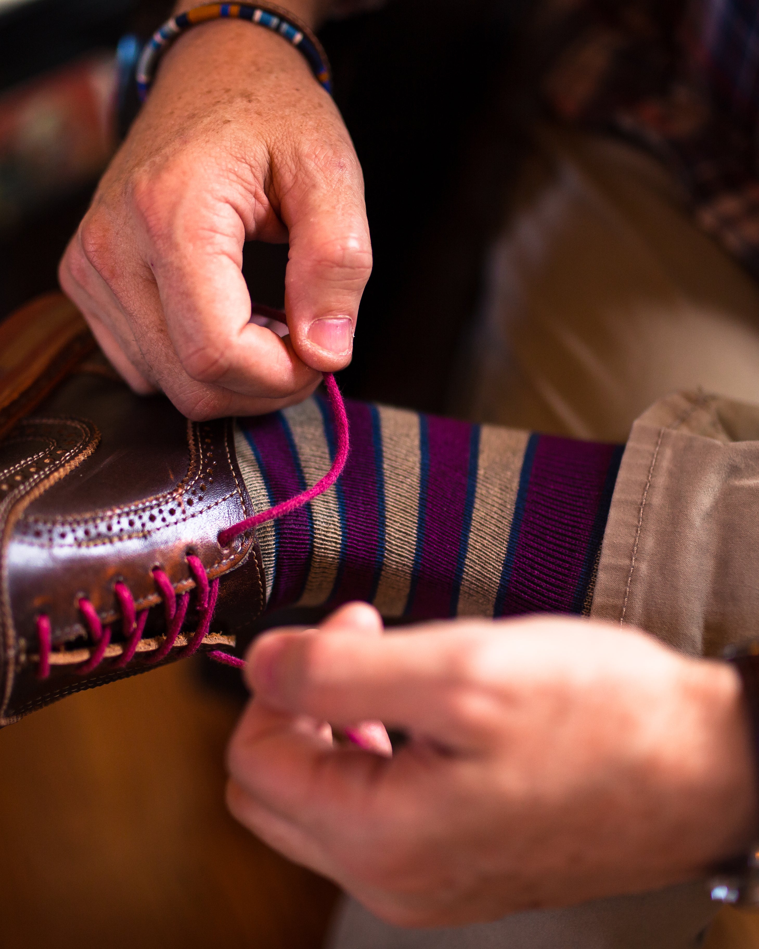 light brown and burgundy striped over the calf dress socks, brown dress shoes with pink laces, brown pants