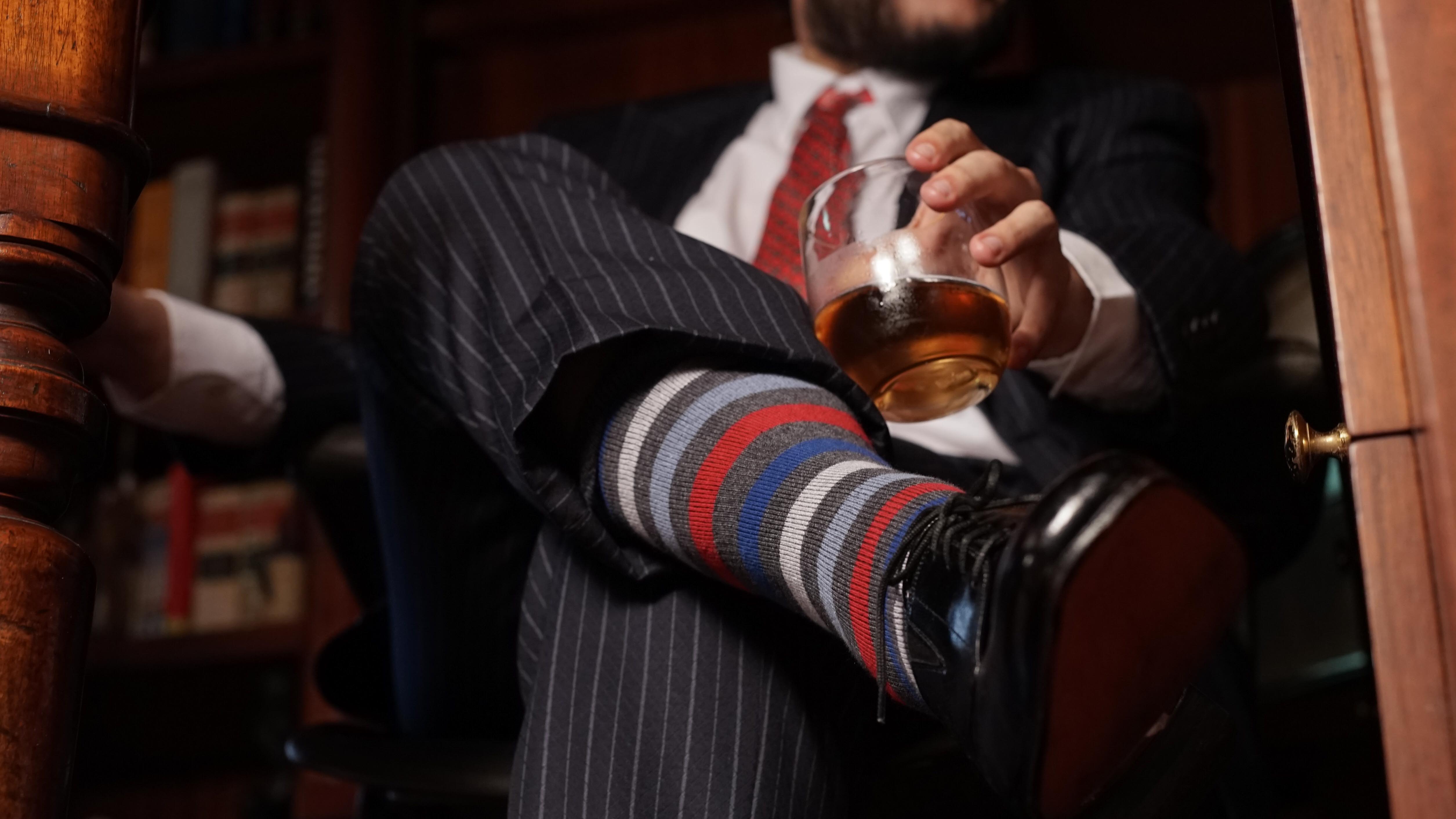 grey over the calf dress socks with red blue and beige striped pattern, black dress shoes, black dress pants