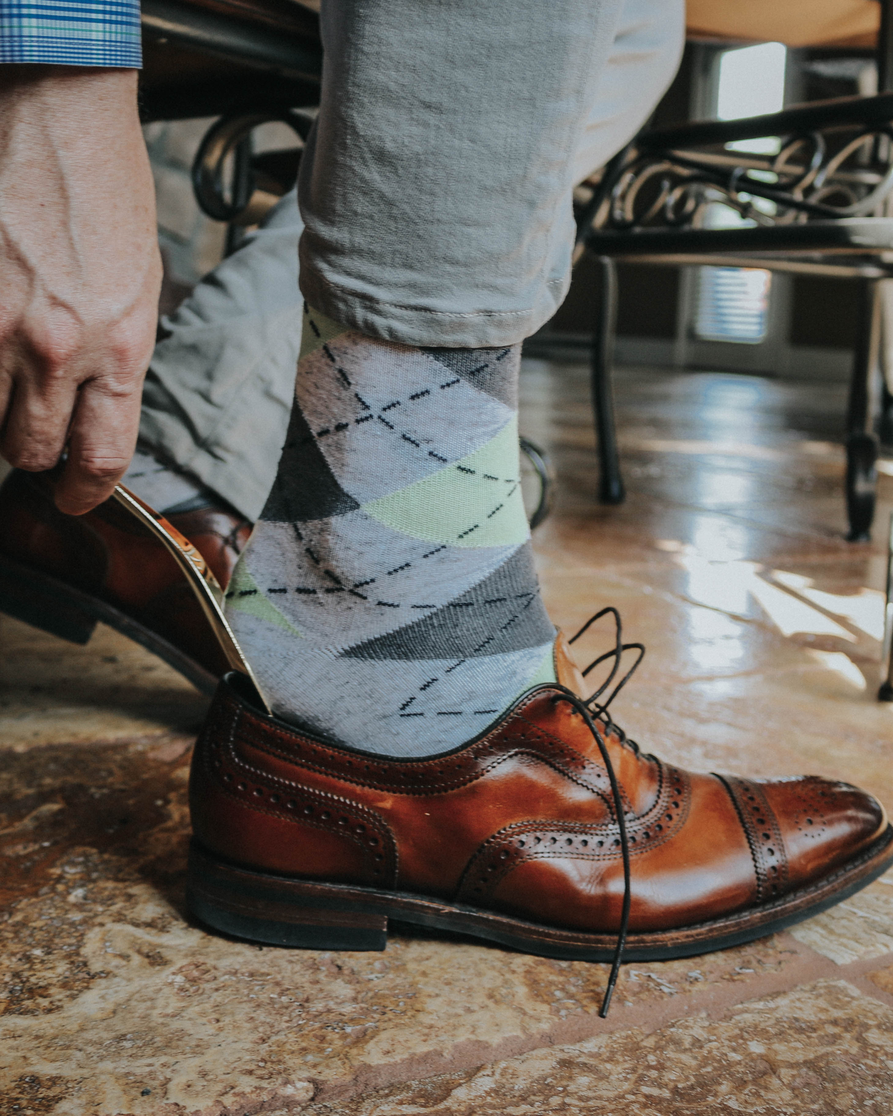 grey and green argyle print over the calf dress socks, brown dress shoes, grey casual pants