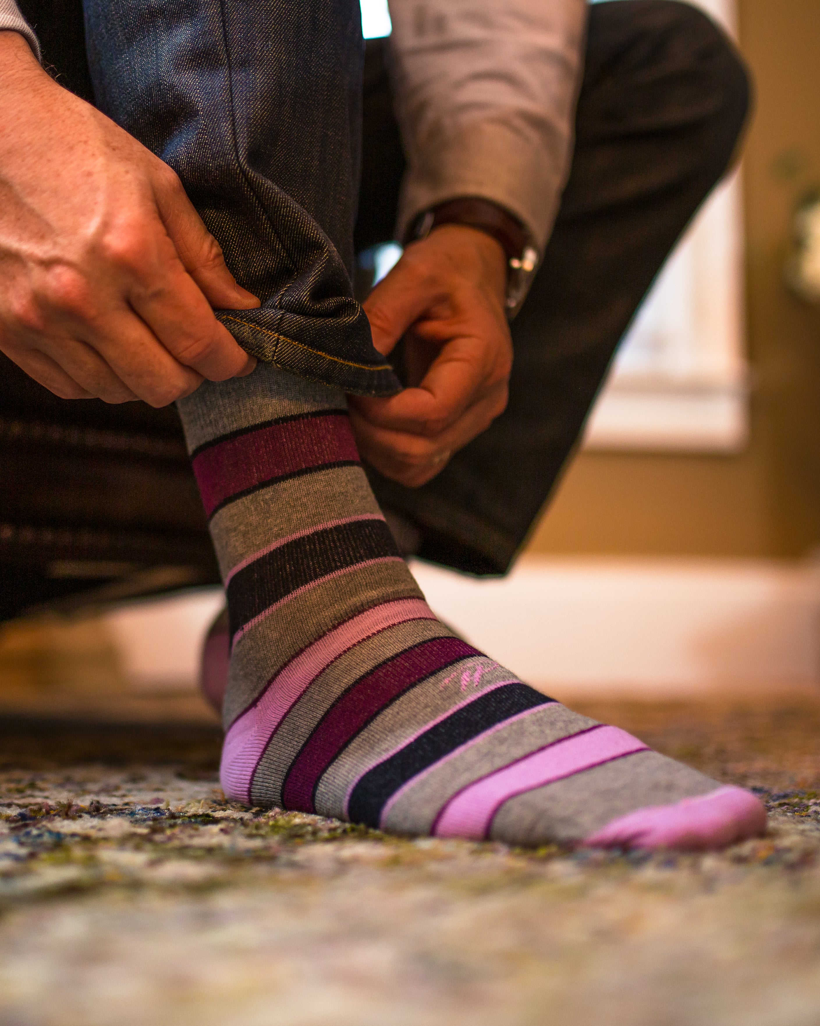 grey over the calf dress socks with pink burgundy and black stripes, blue jeans, watch