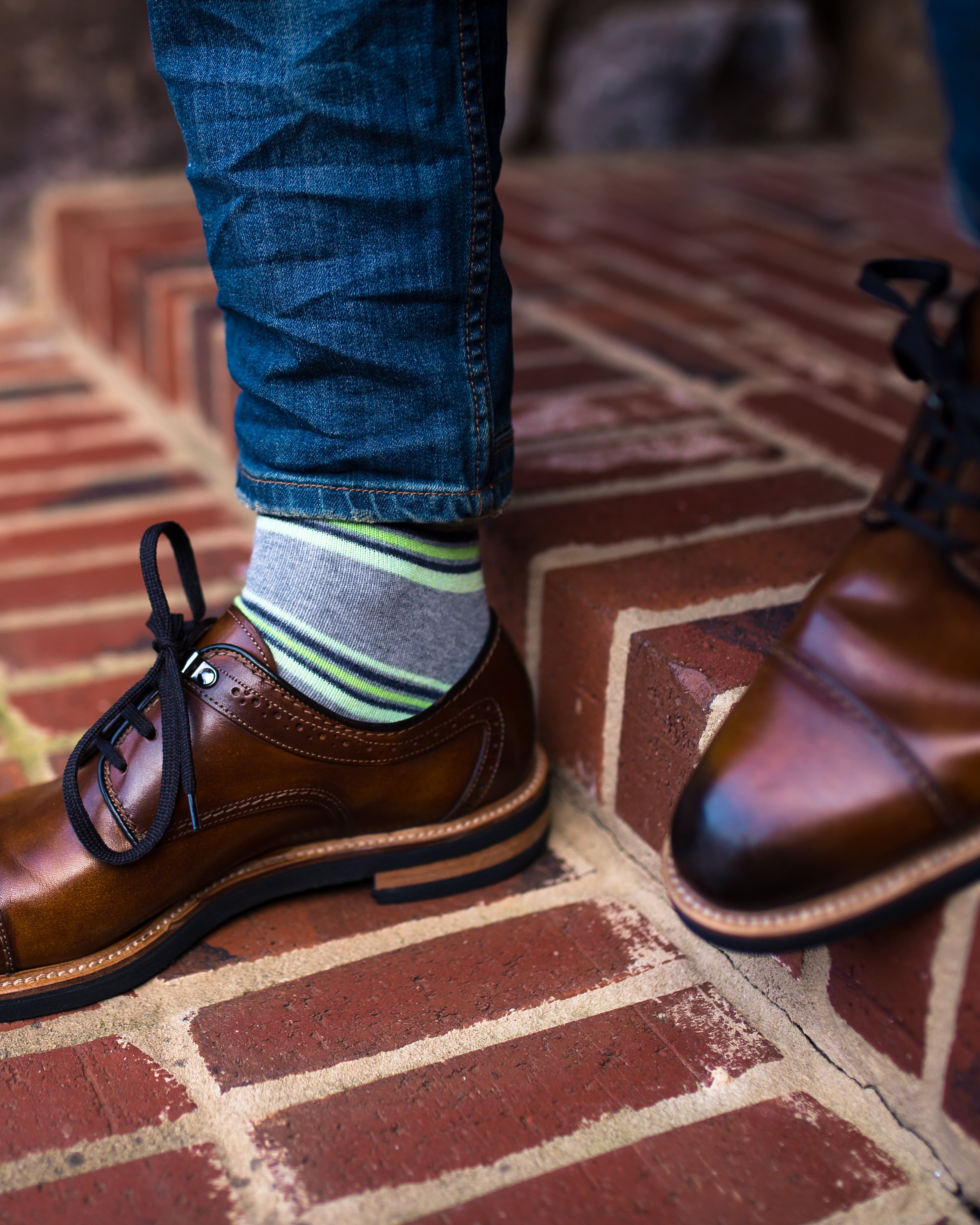 light grey over the calf dress socks with lime green stripes, brown dress shoes with black laces, blue jeans