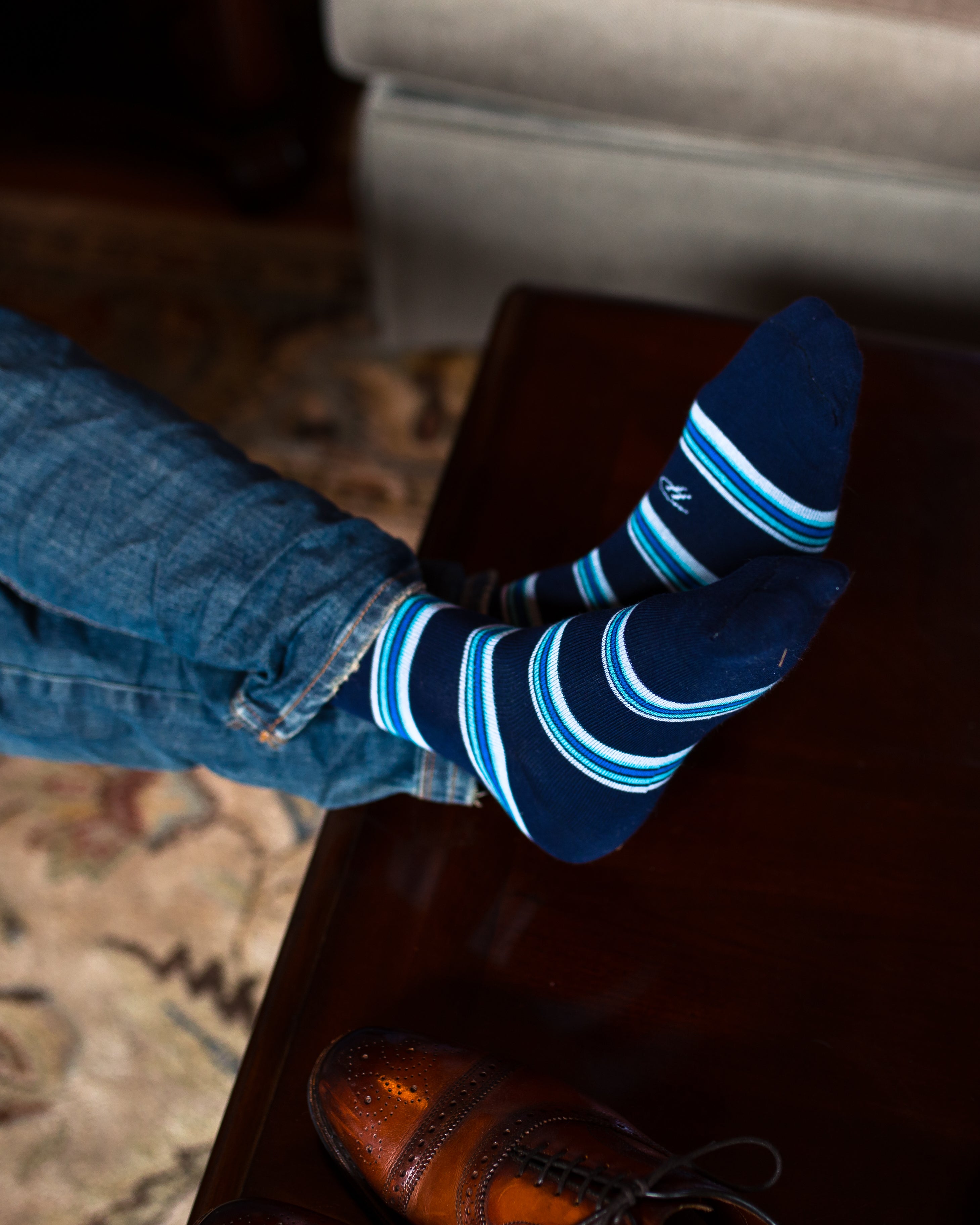 navy blue over the calf dress socks with blue aqua and white stripes, blue jeans, brown dress shoes