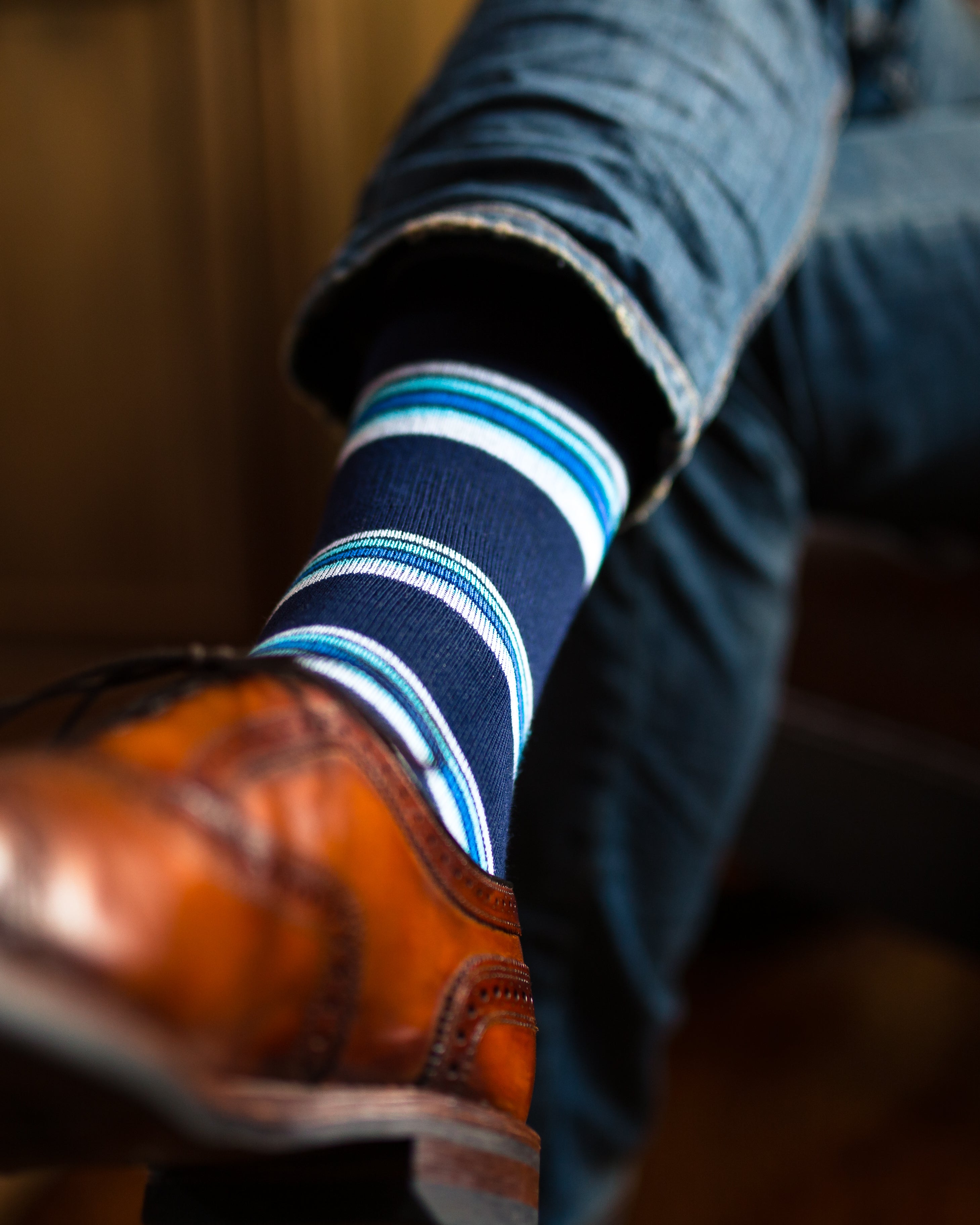 navy blue over the calf dress socks with blue light pink and light blue stripes, blue jeans, brown dress shoes