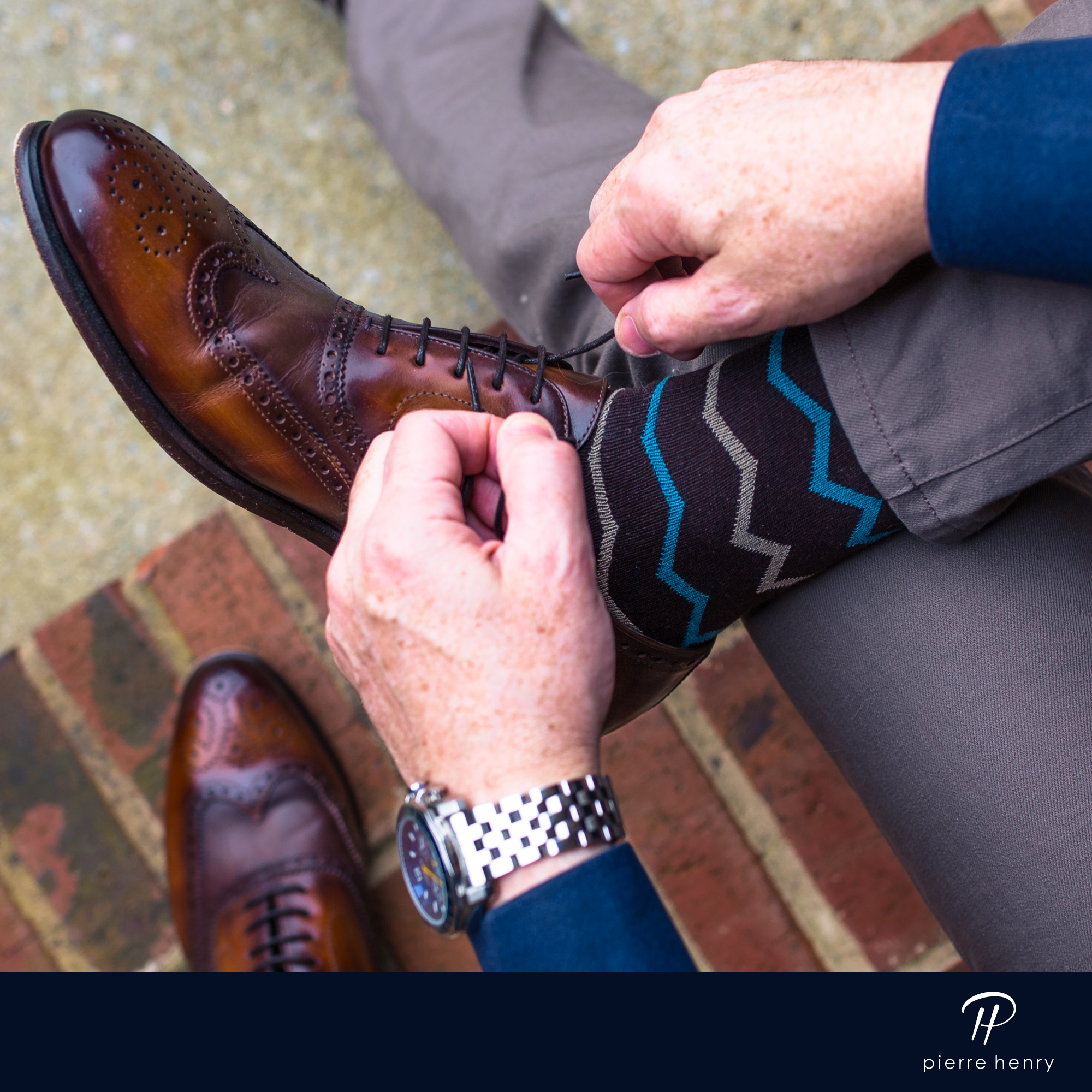 purple over the calf dress socks with blue and grey zigzag lines, brown dress shoes, grey pants, silver watch