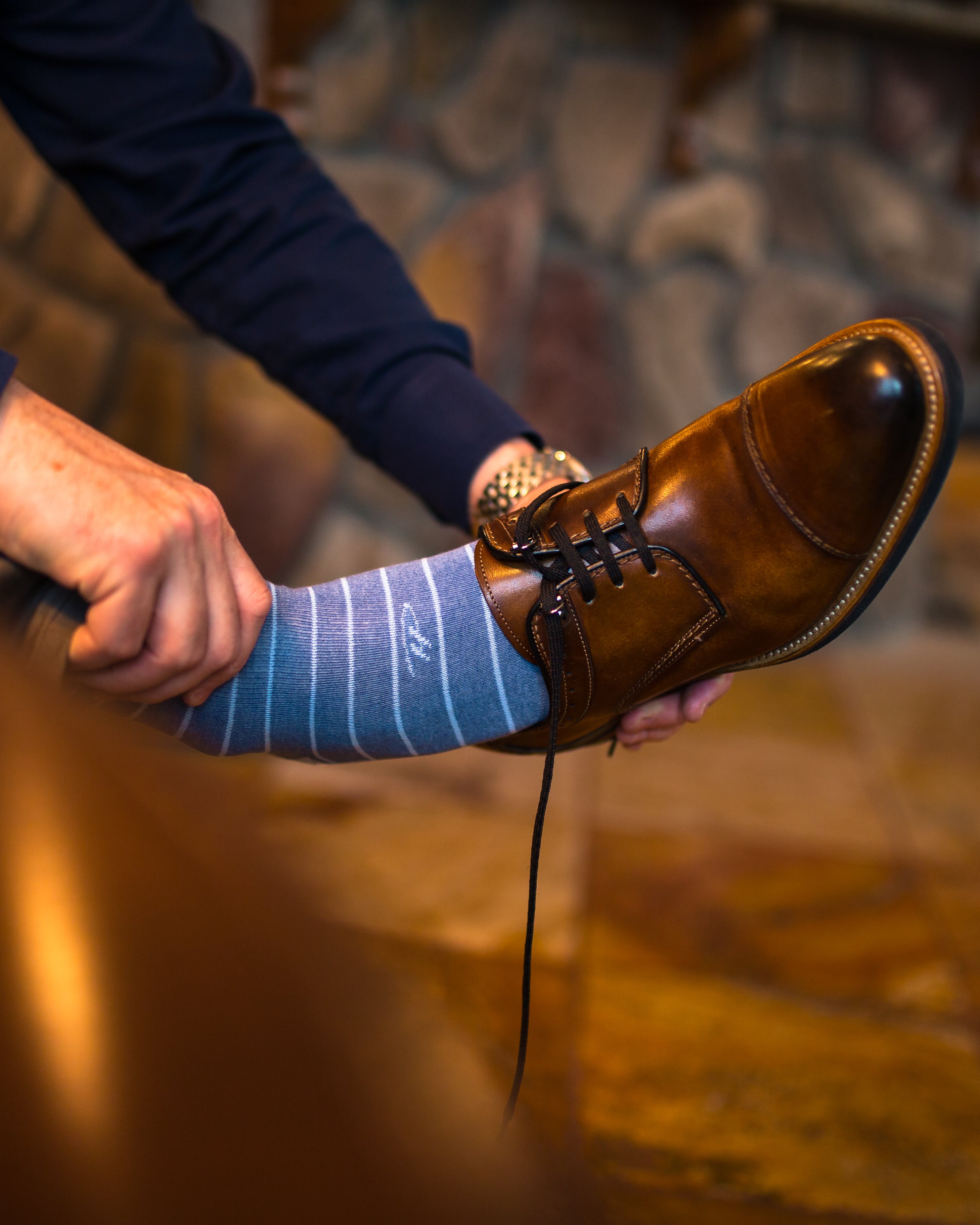blue over the calf dress socks with light blue stripes, brown dress shoes, a watch, navy blue shirt