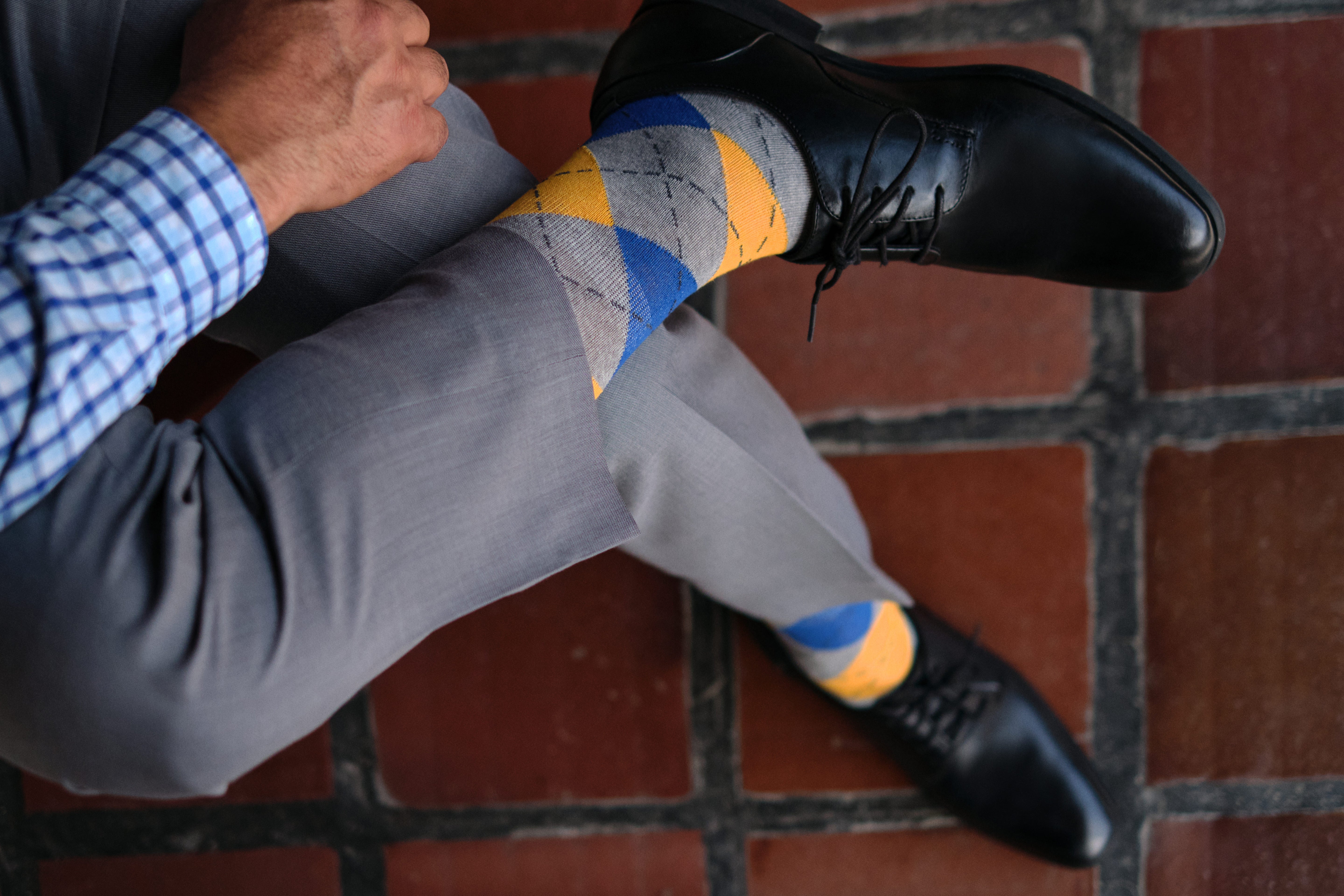 argyle grey blue and orange mid calf dress socks, black dress shoes, grey dress pants, plaid dress shirt