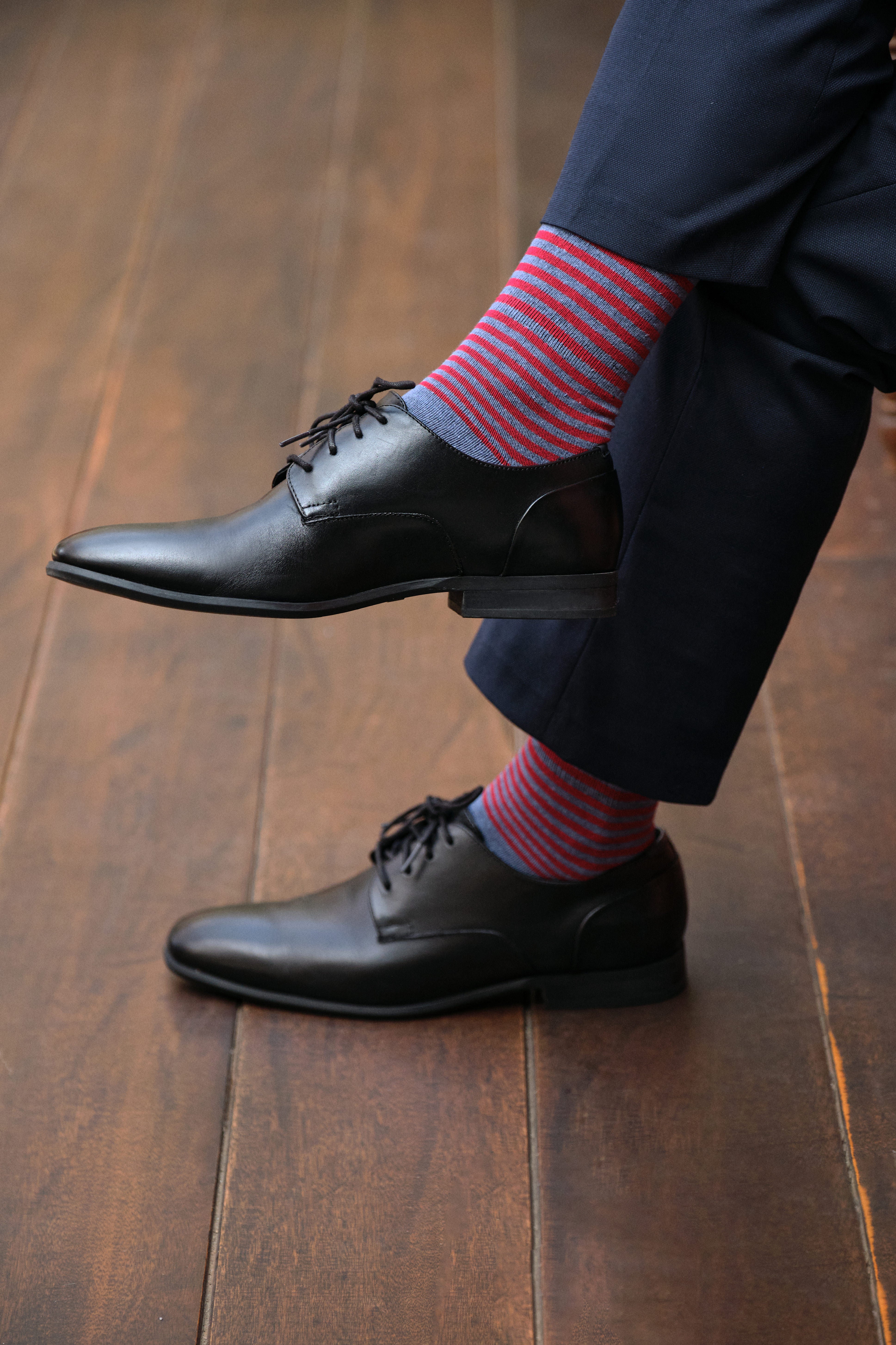light blue mid calf dress socks with red stripes , navy dress pants, black dress shoes