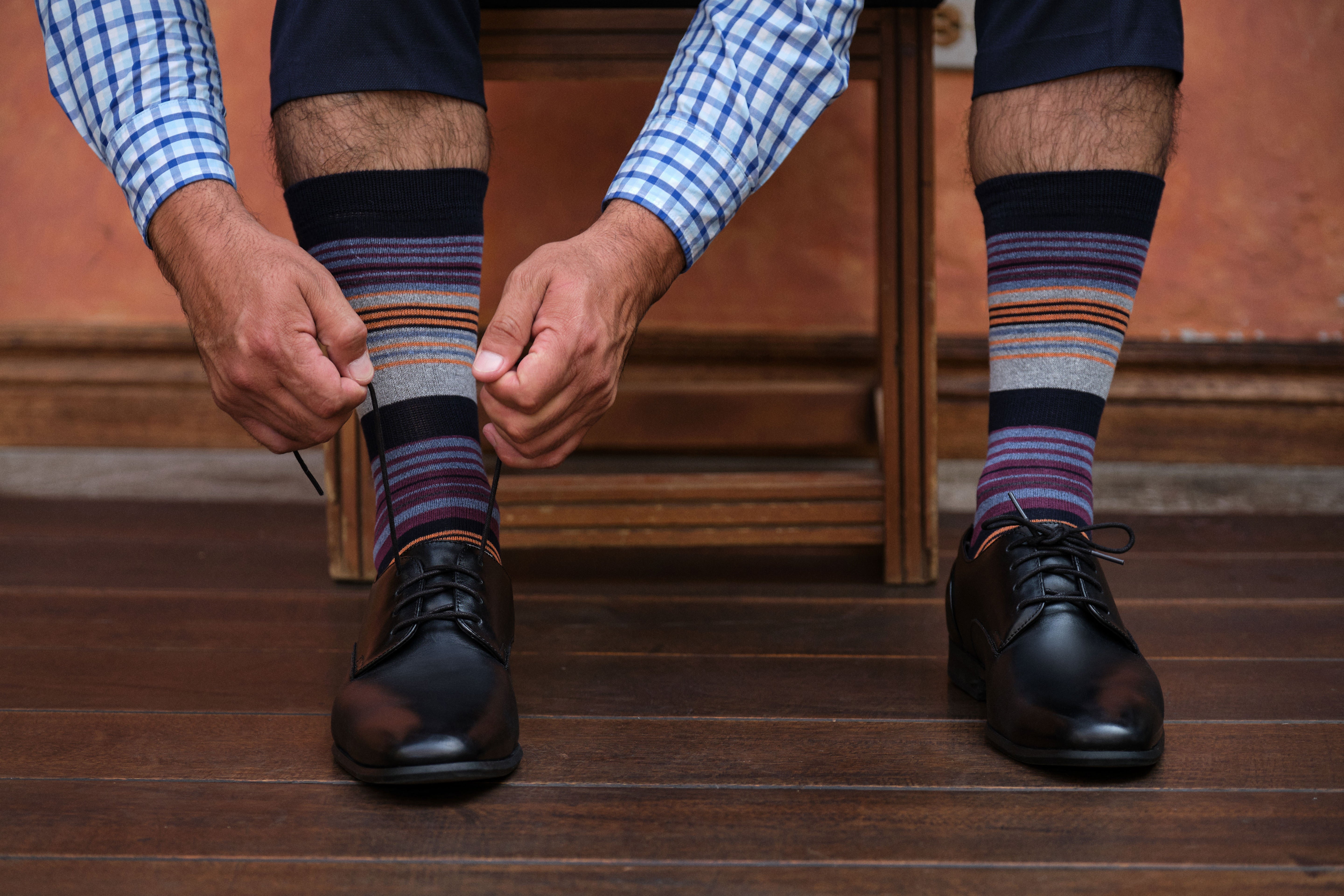 light grey mid calf dress socks with burgundy blue and orange stripes, black dress shoes